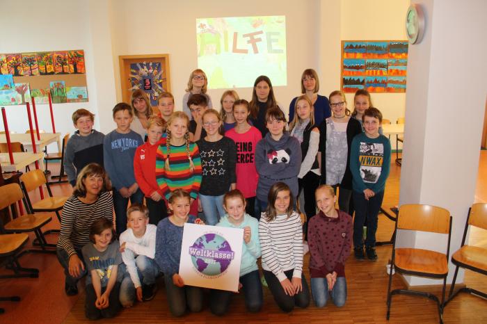 Gruppenfoto der Schüler*innen der Seeadlerklasse in Wismar, die das Weltklasse! Siegel in die Kamera halten.