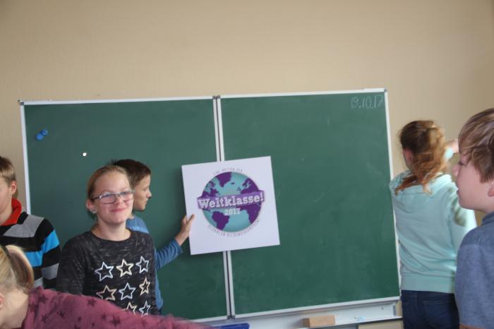 Die Schüler*innen der Evangelischen Schule Robert Lansemann überlegen, wo sie ihr neues Weltklasse! Siegel im Klassenzimmer aufhängen möchten.