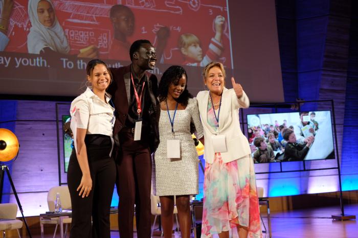 Tanya, Jugendbotschafterin der GBK, Nhial Deng, ONE Aktivist, Vicky Mogeni, Global Campaign for Education, Yasmine Sherif, EducationCannotWait stehen zusammen auf der Bühne, lachen, Yasmine Sherif zeigt den Daumen nach oben